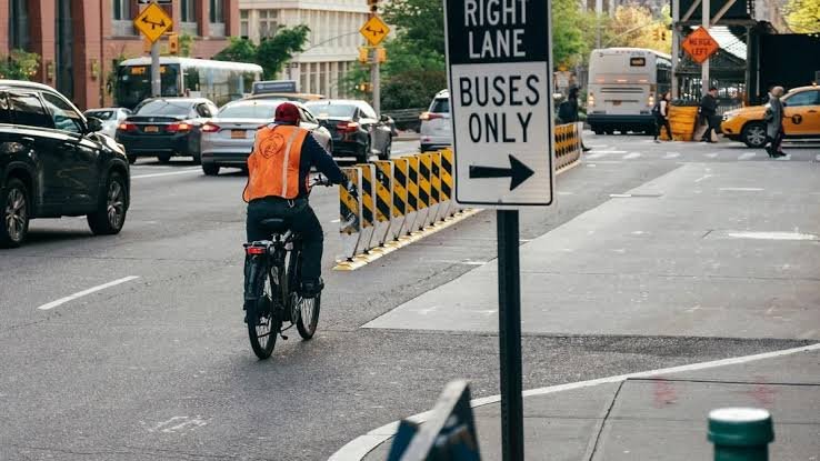 Cyclist riding safely beside cars in an urban bike lane